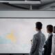 Employees in a conference room with large windows discussing what is whitespace analysis